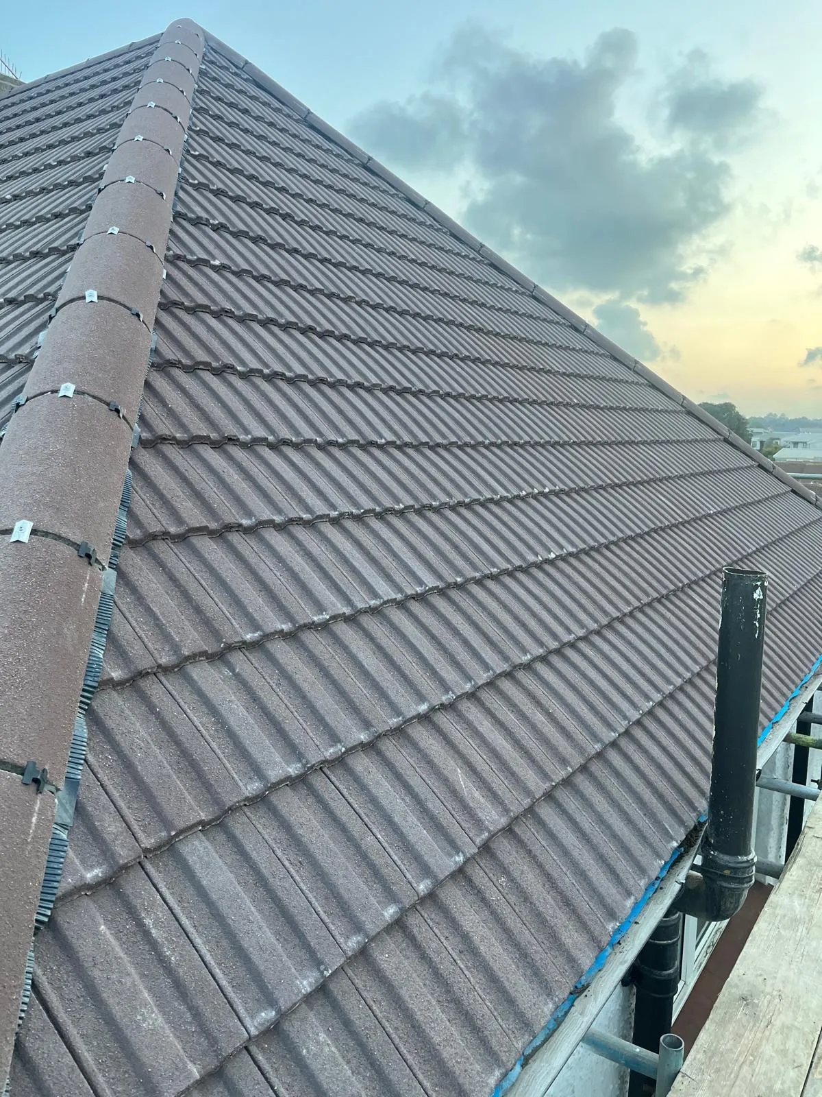 Finished tiled roof and ridge line photographed at dusk