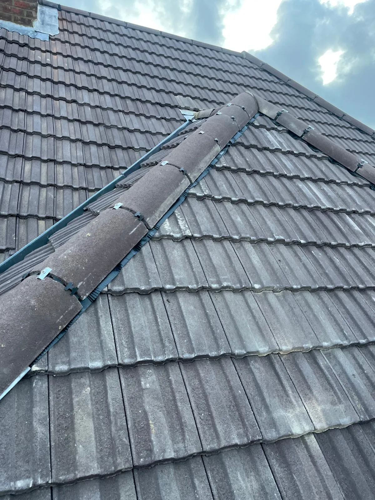 Finished roof with new ridge line against a blue sky