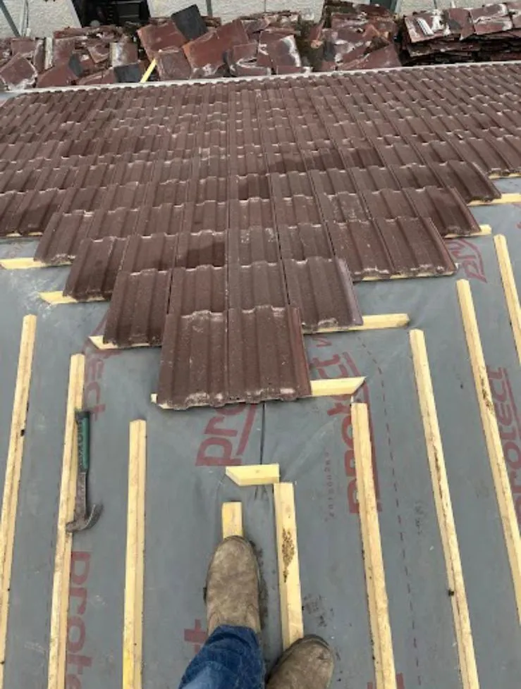 Tiles being laid in courses up the roof