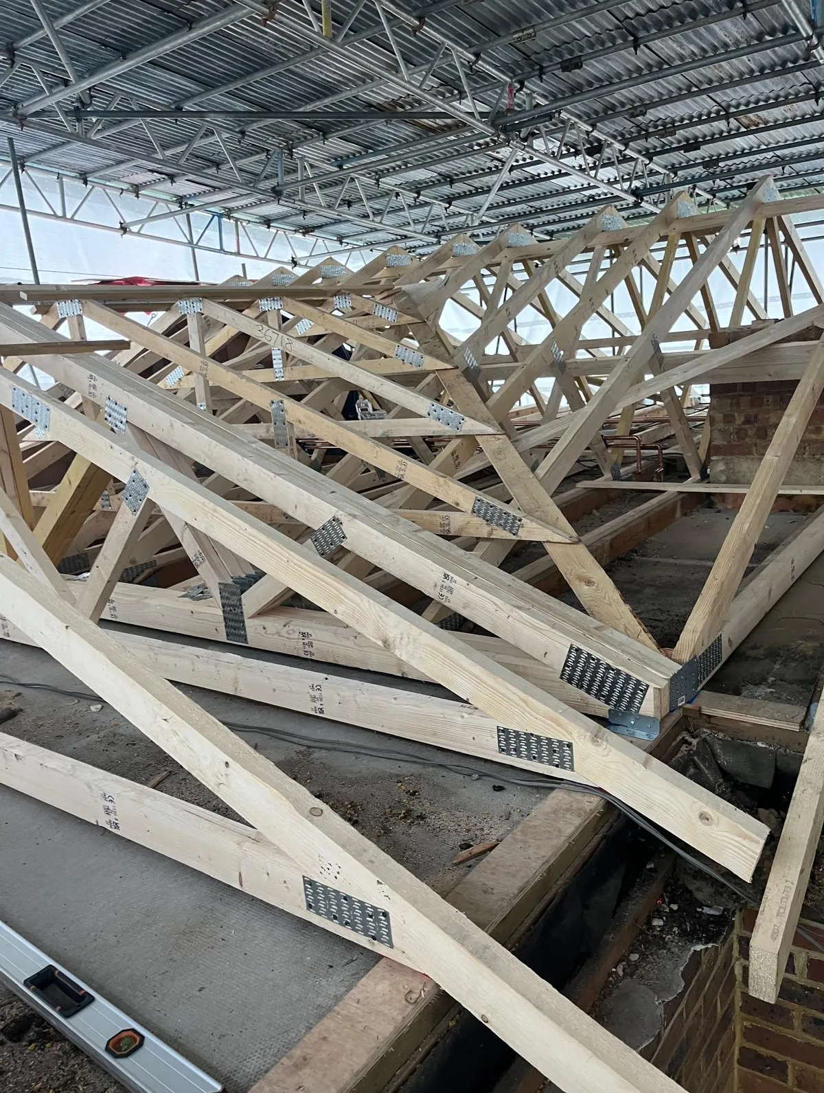 New roof trusses fixed in place, seen from inside the frame
