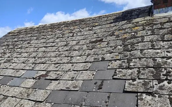 Old slate roof repaired with new slates let into the original coursing