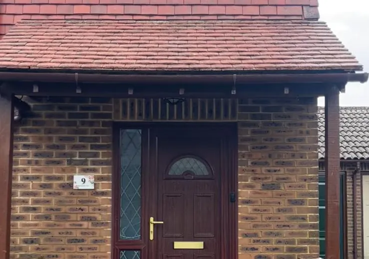 Porch canopy roof of red plain tiles, the moss cleaned off