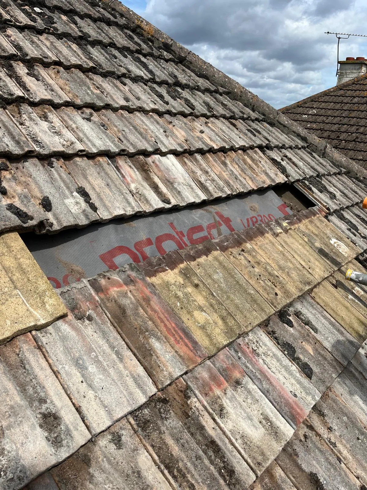 Tiles off in a band across the roof, membrane showing underneath