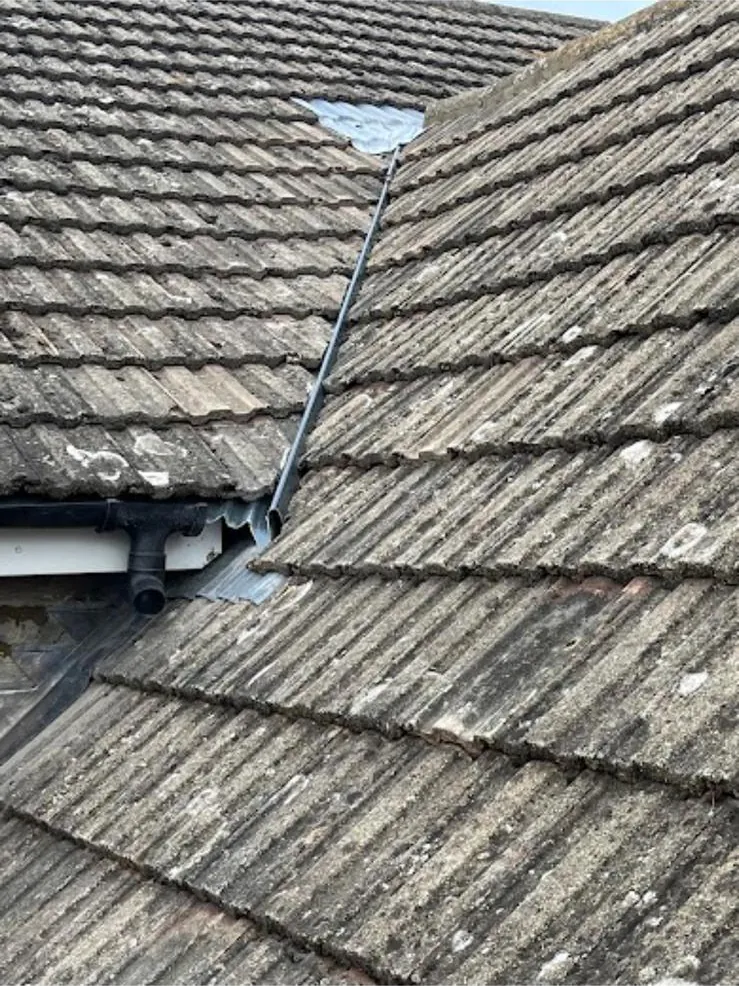 Tiled roof with a gap at the top of the valley where tiles have gone