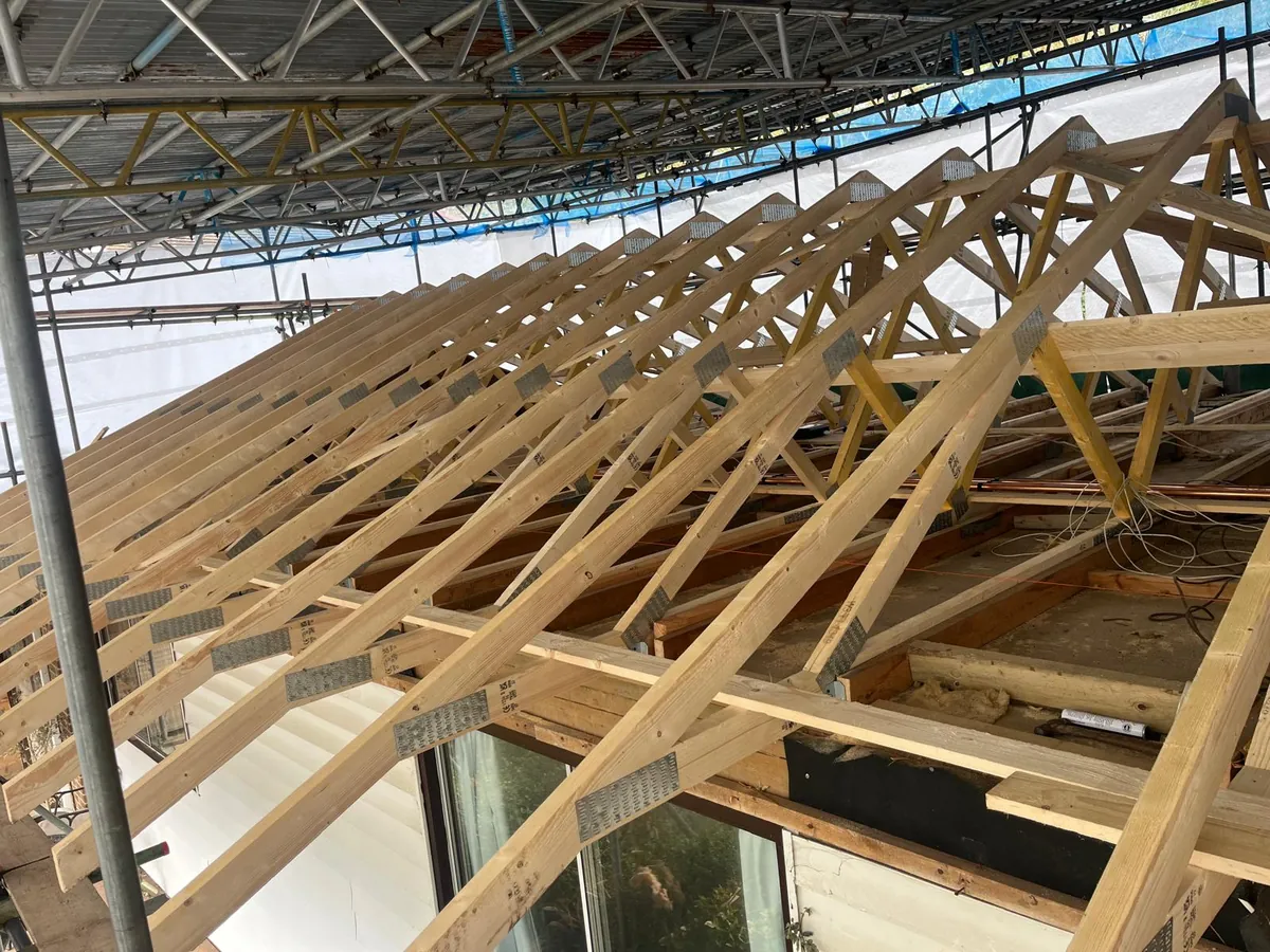 Roof trusses going up under a temporary scaffold roof