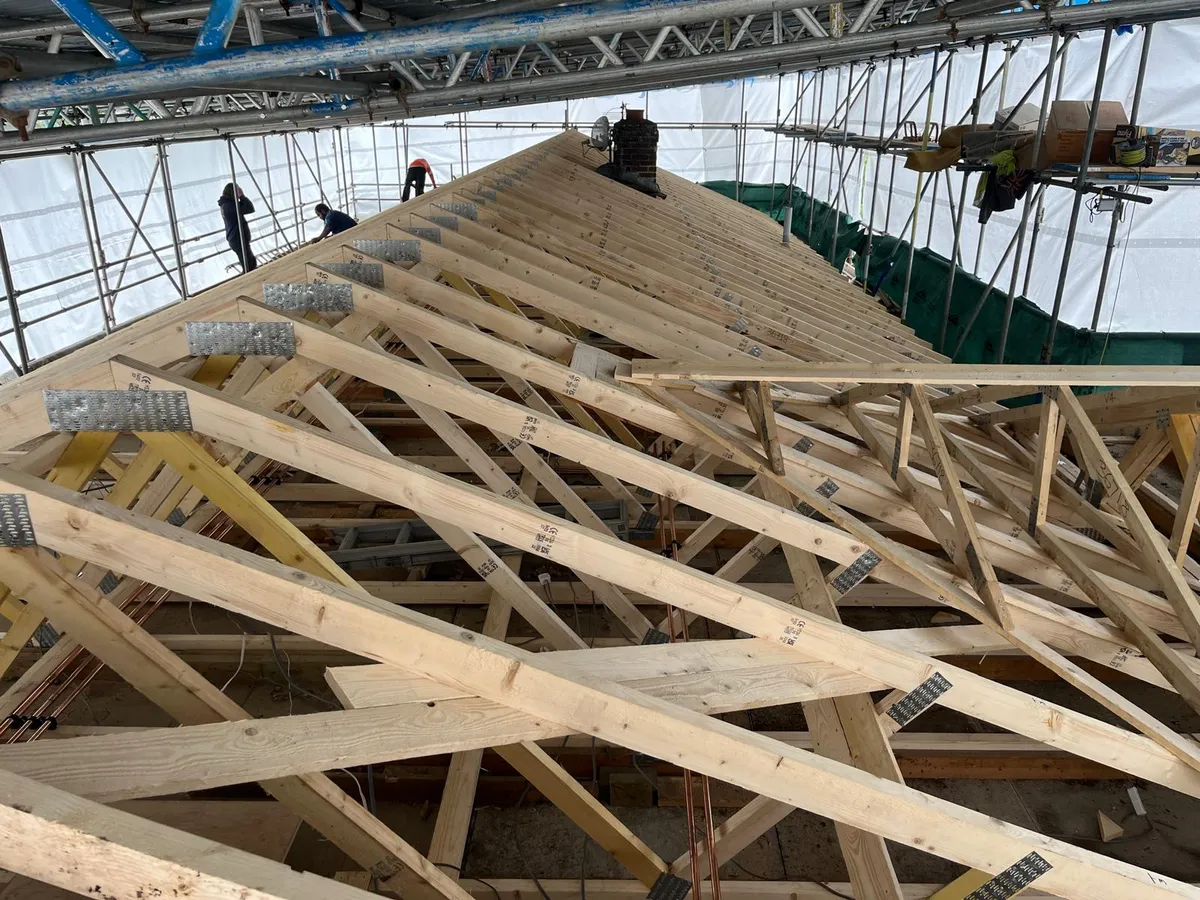 New timber roof trusses erected under a temporary scaffold roof