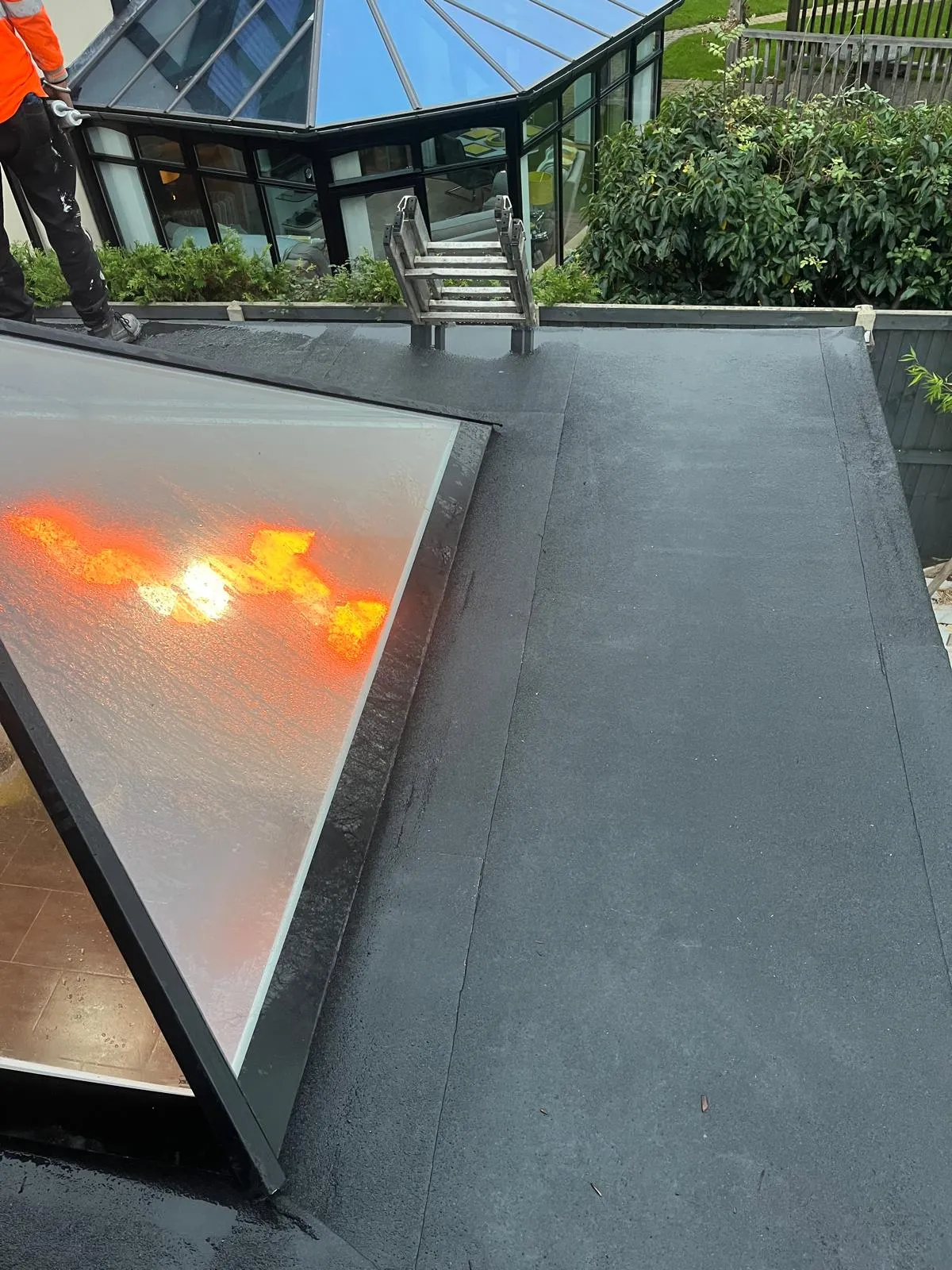 Finished black flat roof with a new glass skylight
